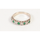 AN 18ct WHITE GOLD TINY DIAMOND AND EMERALD SET HALF HOOP RING, 3.7gms gross