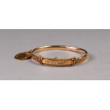 VICTORIAN 15ct GOLD HOLLOW HINGE OPENING BANGLE, the fancy filigree decorative top set with a row of