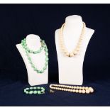 TWO VICTORIAN SINGLE STRAND NECKLACES OF GRADUATED ROUND IVORY BEADS; long necklace of green oval