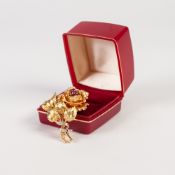 9ct GOLD ROSE SPRAY BROOCH, the bloom centred by three rubies, the stems tied by two white gold