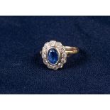 18ct GOLD, SAPPHIRE AND DIAMOND CLUSTER RING, collet set with an oval sapphire and surround of