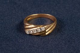 18ct GOLD RING, with spirally fluted top cross set with a centre row of five small round brilliant