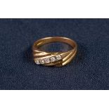 18ct GOLD RING, with spirally fluted top cross set with a centre row of five small round brilliant