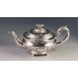 GEORGE III IRISH SILVER TEAPOT, repousse decorated with flowering, scrolling foliage and two
