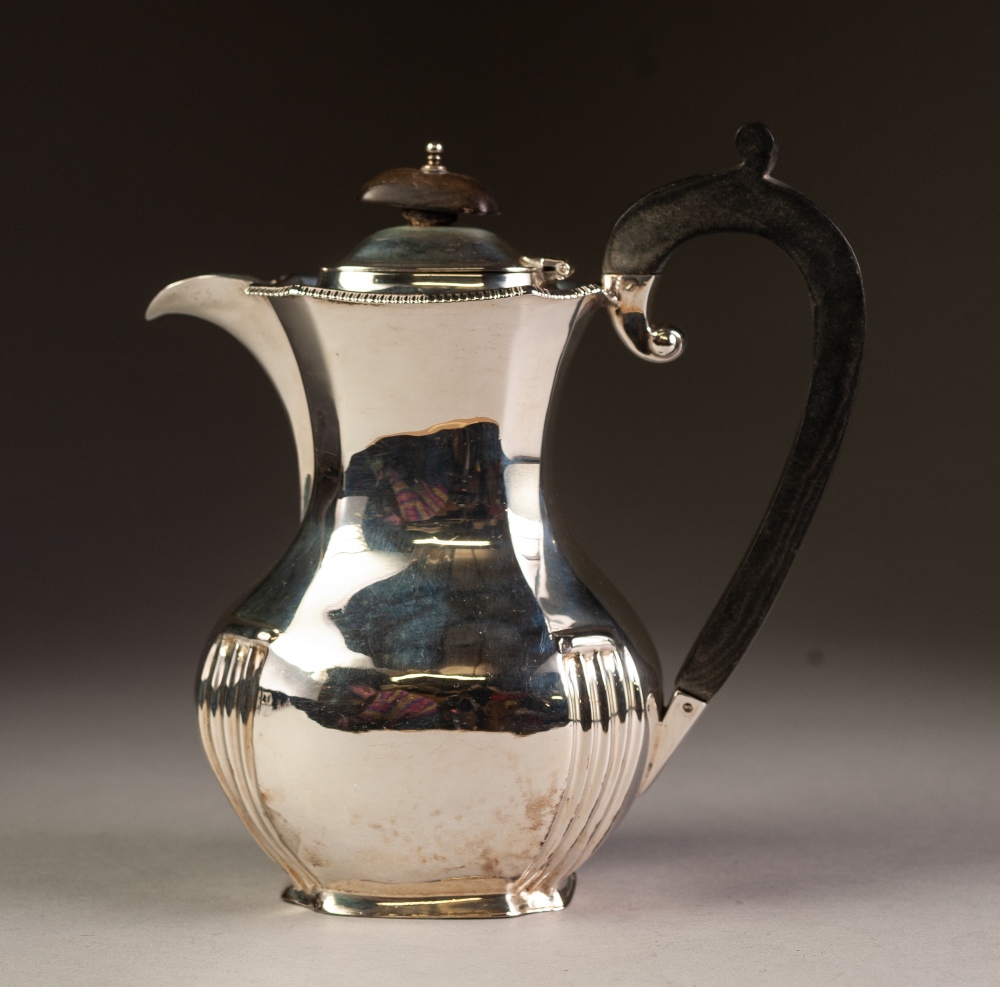 EARLY 20th CENTURY SILVER COFFEE POT of panelled baluster form with narrow gadrooned rim, black wood