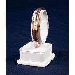 LADY'S BAUME & MERCIER, GENEVE, 18ct GOLD SPRUNG BANGLE WATCH with mechanical movement, tiny