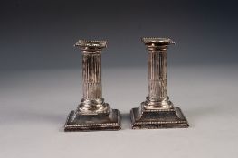 PAIR OF LATE VICTORIAN WEIGHTED SILVER DWARF CANDLESTICKS with stop-fluted stems, removable beaded