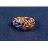 GOLD AND SYNTHETIC SAPPHIRE DRESS RING with an emerald cut sapphire, in a four claw setting with
