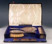 GEORGE V CASED FOUR PIECE PLAIN SILVER HAND MIRROR AND BRUSH SET, including a tortoiseshell comb,