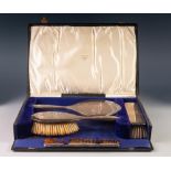 GEORGE V CASED FOUR PIECE PLAIN SILVER HAND MIRROR AND BRUSH SET, including a tortoiseshell comb,