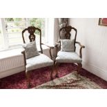 A PAIR OF GEORGE I STYLE CARVED WALNUT CARVERS ARMCHAIRS WITH ORNATE CARVED AND PIERCED SPLAT BACKS,