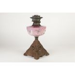 VICTORIAN PINK GLASS AND CAST METAL OIL TABLE LAMP, the floral painted reservoir above a square,