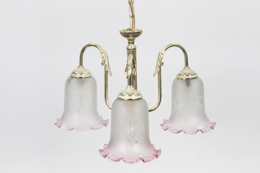 MODERN PAIR OF GILT METAL THREE LIGHT ELECTROLIERS, each with pink tinted and etched downlight