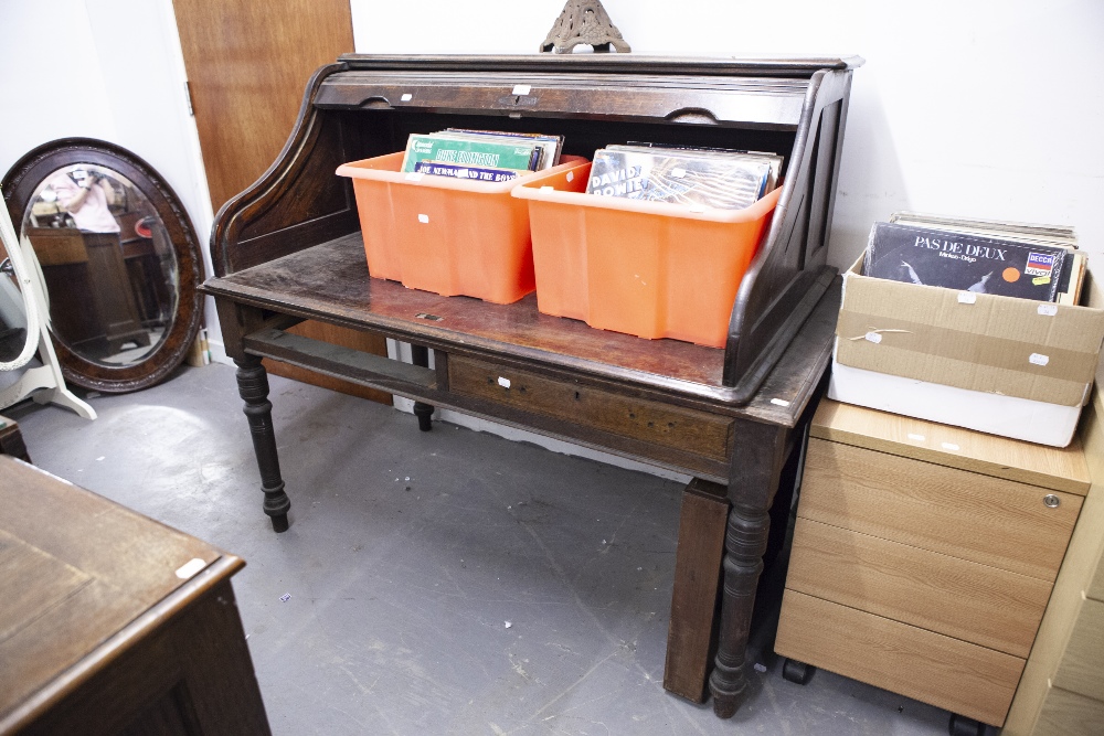 AN OAK DESK TOP WITH SERPENTINE TAMBOUR SHUTTER, 4'6" WIDE (LACKS PEDESTALS), NOW STANDING ON A