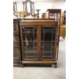 A 1930's OAK BOOKCASE WITH LEADED GLASS DOORS