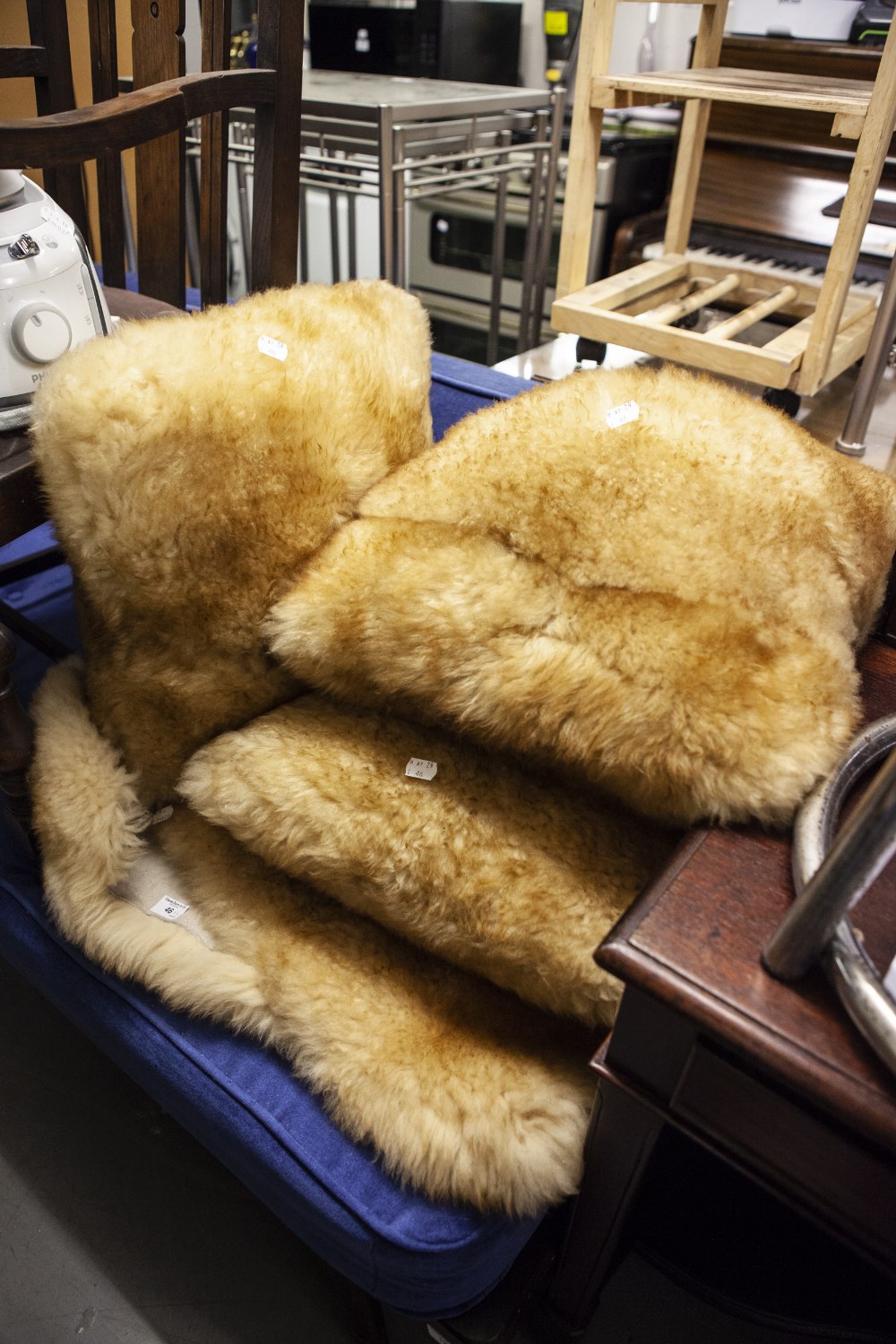 A NATURAL GREY SHEEPSKIN RUG AND A LIGHT BROWN SHEEPSKIN RUG, AND THREE FUR FABRIC CUSHIONS