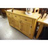 A SOLID LIGHT WOOD SIDEBOARD WITH THREE DRAWERS ABOVE THREE CUPBOARD DOORS AND INTERIOR GLASS