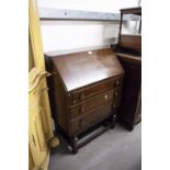 OAK BUREAU HAVING THREE DRAWERS, FALL FRONT ON ON BULBOUS FRONT SUPPORTS