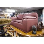 A TWO SEATER BURGUNDY LEATHER SETTEE WITH FITTED CUSHIONS