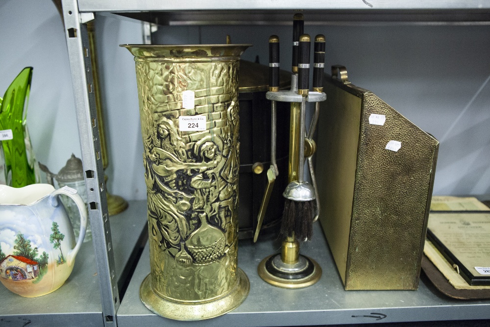 A BRASS UMBRELLA STAND, WITH REPOUSSE DECORATION, A BRASS MAGAZINE RACK WITH SAILING BOAT,