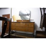 A 1970's DRESSING CHEST, SHAPED MIRROR OVER SHORT DRAWERS, THE BASE HAVING TWO LONG DRAWERS ON