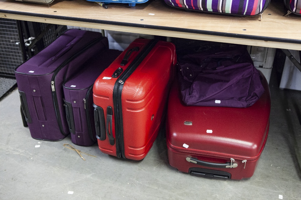 TWO GRADUATED PURPLE SUITCASES, A HARDSHELL RED 'ELLEHAMMER' SUITCASE, ANOTHER HARDSHELL SUITCASE