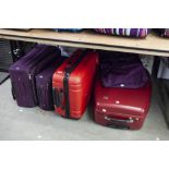 TWO GRADUATED PURPLE SUITCASES, A HARDSHELL RED 'ELLEHAMMER' SUITCASE, ANOTHER HARDSHELL SUITCASE