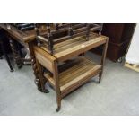 A POLISHED WOOD AND WOOD EFFECT FORMICA TWO TIER TEA TROLLEY, ADJUSTING TO FORM A TABLE