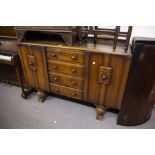 EDWARDIAN OAK SIDEBOARD HAVING FOUR CENTRAL DRAWER CUPBOARD TO EITHER SIDE, ALL RAISED ON CARVED CUP