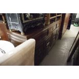 AN ORIENTAL DARK WOOD SIDEBOARD, THREE DRAWERS ABOVE THREE DOORS WITH DECORATIVE CARVED PANELS