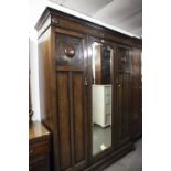 JACOBEAN STYLE OAK THREE DOOR WARDROBE WITH CENTRAL MIRROR PANEL DOOR AND WITH BLIND FRET CARVED