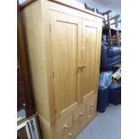 A MODERN LIGHT OAK TWO DOOR WARDROBE AND A PAIR OF MATCHING TWO DRAWER BEDSIDE CABINETS (3)