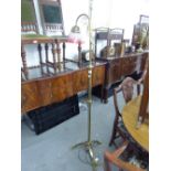 AN EARLY TWENTIETH CENTURY BRASS STANDARD LAMP WITH SCROLL HANDLE OVER SHAPED ARM AND CRANBERRY