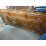 AN ORIENTAL DARK WOOD SIDEBOARD, THREE DRAWERS ABOVE THREE DOORS WITH DECORATIVE CARVED PANELS