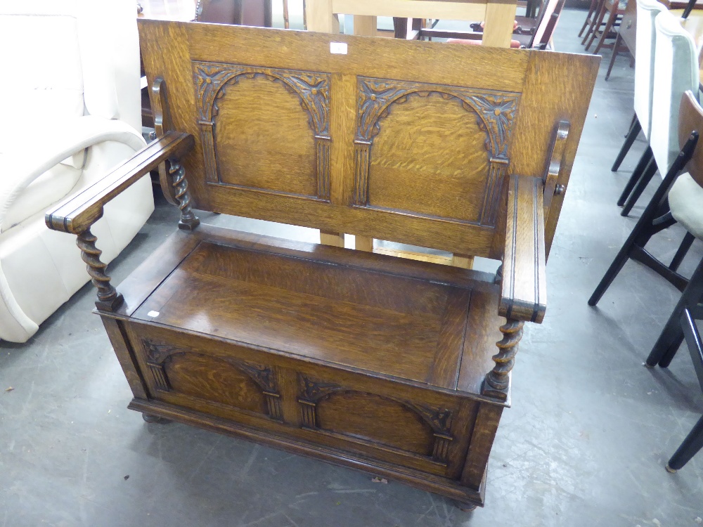 AN EARLY TWENTIETH CENTURY OAK MONKS BENCH, THE FLIP/BACK WITH BARLEY TWIST SUPPORTS, HAVING