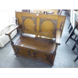 AN EARLY TWENTIETH CENTURY OAK MONKS BENCH, THE FLIP/BACK WITH BARLEY TWIST SUPPORTS, HAVING