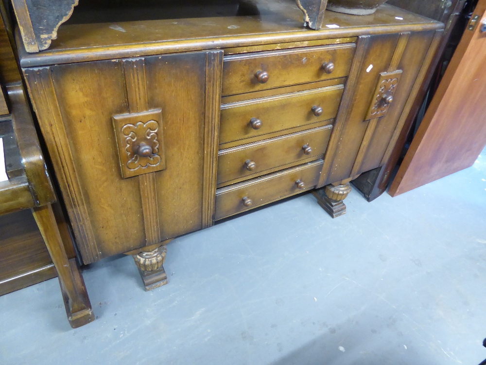 EDWARDIAN OAK SIDEBOARD HAVING FOUR CENTRAL DRAWER CUPBOARD TO EITHER SIDE, ALL RAISED ON CARVED CUP