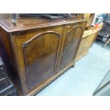 A LARGE CIRCA 1930's BURR WALNUTWOOD TWO DOOR SIDE CABINET OR DRINKS CABINET, ENCLOSING A CERAMIC