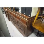 AN ORIENTAL DARK WOOD SIDEBOARD, THREE DRAWERS ABOVE THREE DOORS WITH DECORATIVE CARVED PANELS