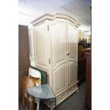 A LIMED OAK TWO DOOR CONTINENTAL WARDROBE WITH ARCH TOP