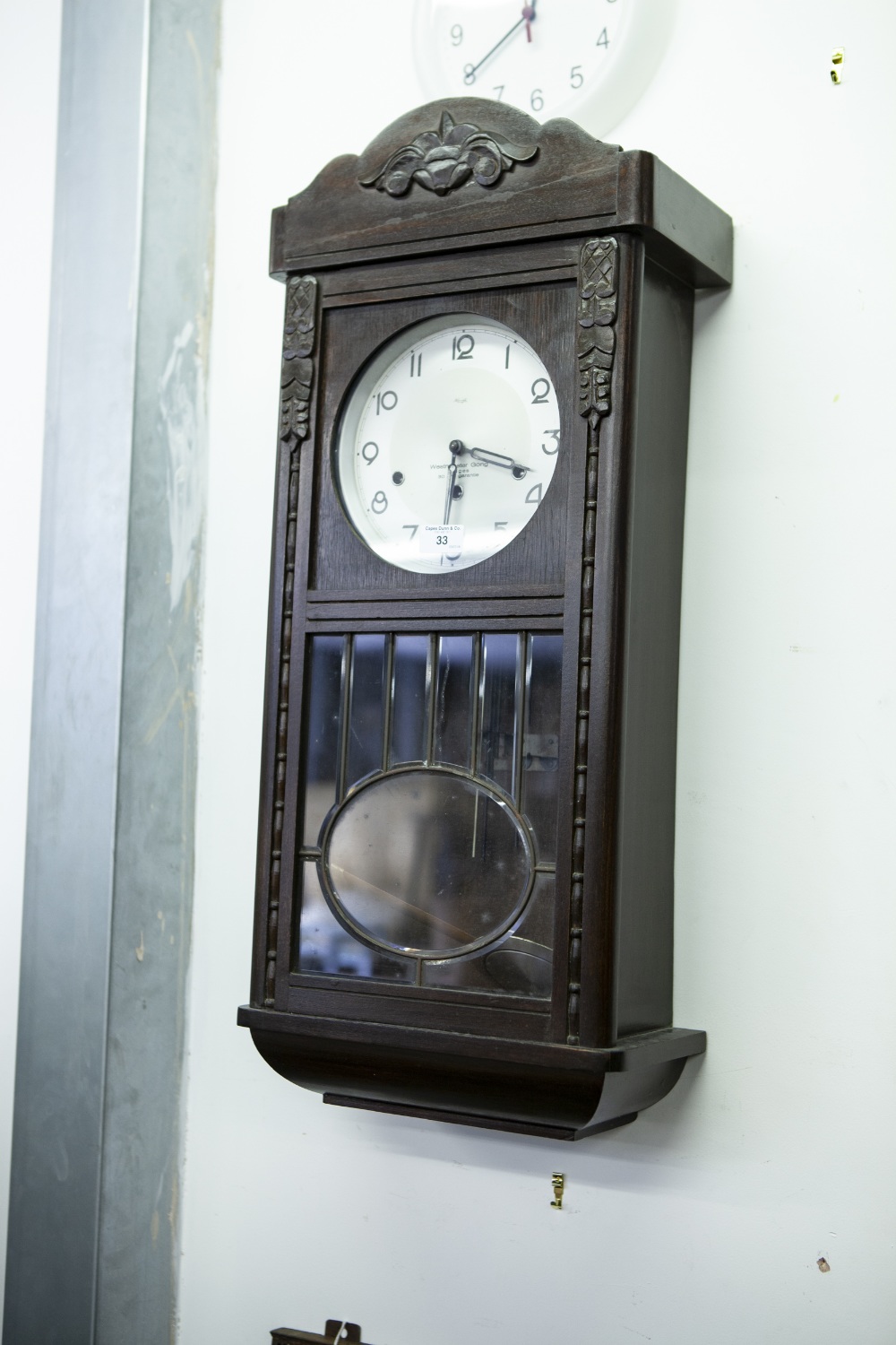 AN EIGHT DAY CLOCK, 30" TALL, SILVERED DIAL AND GLAZED LOWER SECTION IN DOOR, MADE BY KIENZLE IN