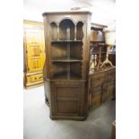 A CARVED DOUBLE CORNER CUPBOARD WITH OPEN SHELVES OVER A CUPBOARD BASE