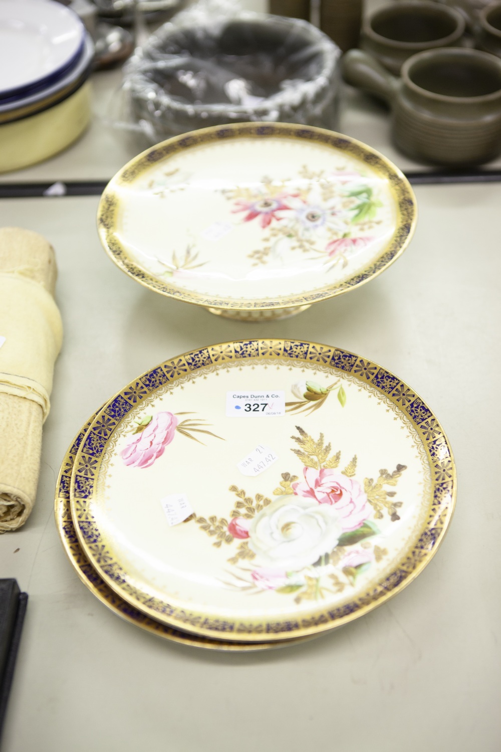 A SET OF EARLY TWENTIETH CENTURY PAINTED PLATES WITH YELLOW GROUND AND HAND PAINTED FLOWERS