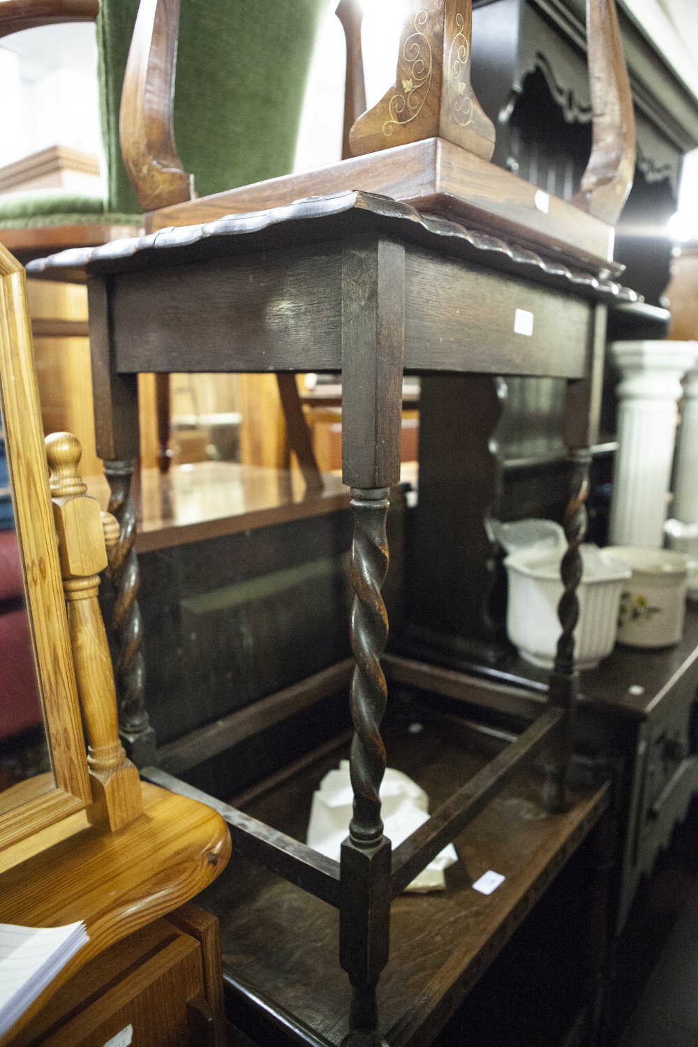 AN OAK OBLONG OCCASIONAL TABLE ON SPIRAL LEGS AND AN OBLONG BEVELLED EDGE WALL MIRROR WITH CARVED