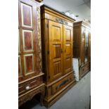 A MODERN STAINED WOOD DOUBLE WARDROBE WITH PANEL DOORS AND LARGE DRAWER TO BASE, WITH TUDOR ROSE