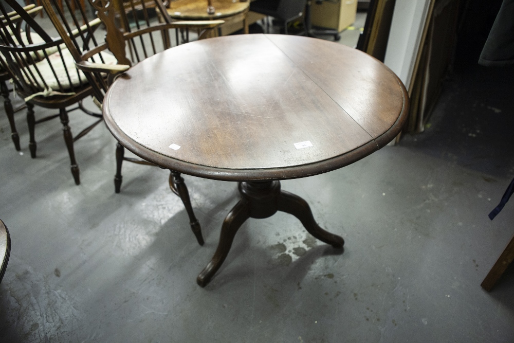 MAHOGANY CIRCULAR TILT-TOP TABLE ON TURNED CENTRAL COLUMN AND THREE CURVED LEGS