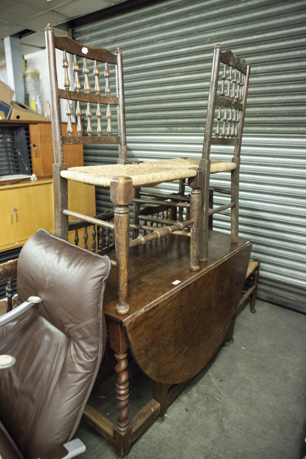 SOLID OAK DROP-LEAF DINING TABLE, A SET OF SIX OAK SPINDLE BACK DINING CHAIRS WITH RUSH SEATS AND