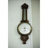 AN EARLY TWENTIETH CENTURY CARVED WALNUTWOOD BANJO BAROMETER AND THERMOMETER
