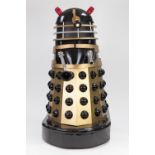 BLACK, SILVER AND GOLD PAINTED MANUFACTURED BOARD AND FIBREGLASS MODEL OF A DALEK, with white