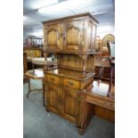 AN EDWARDIAN OAK COCKTAIL CABINET IN THE JACOBEAN STYLE, CUPBOARD RAISED OVER OPEN COMPARTMENT,